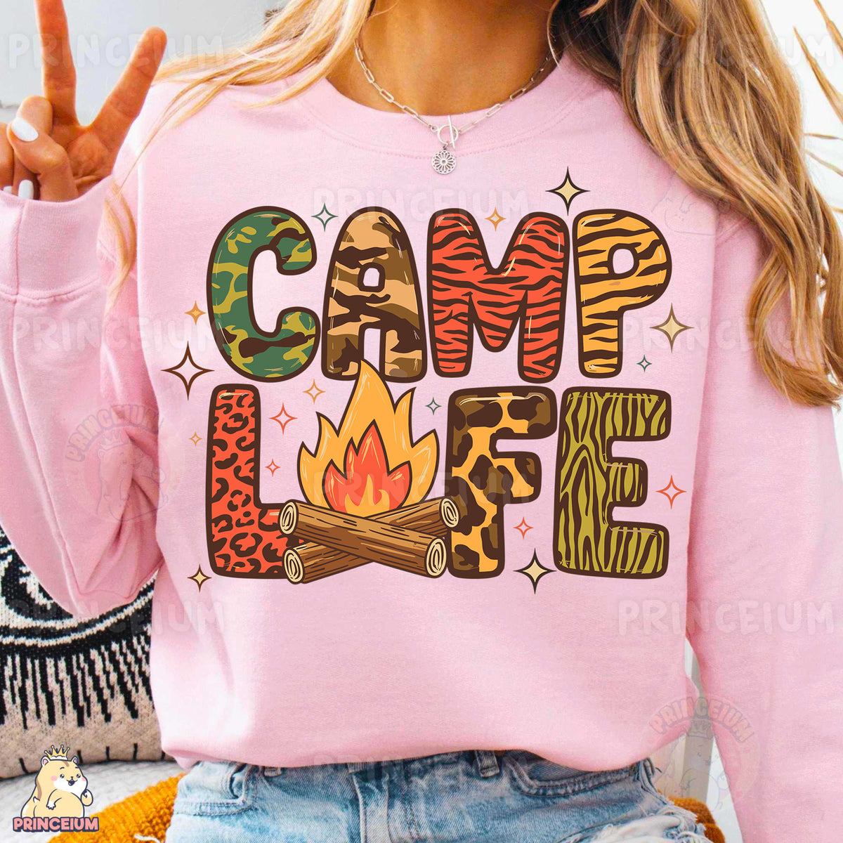 a woman wearing a pink sweatshirt that says camp life