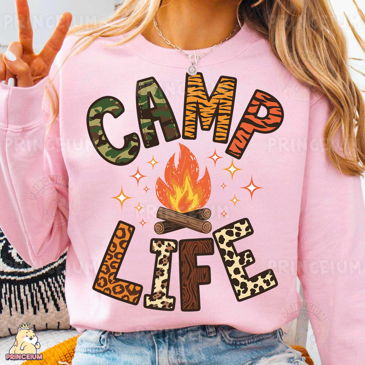 a woman wearing a pink sweatshirt that says camp life