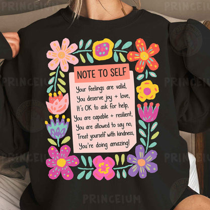 a woman wearing a black shirt with a note to self on it