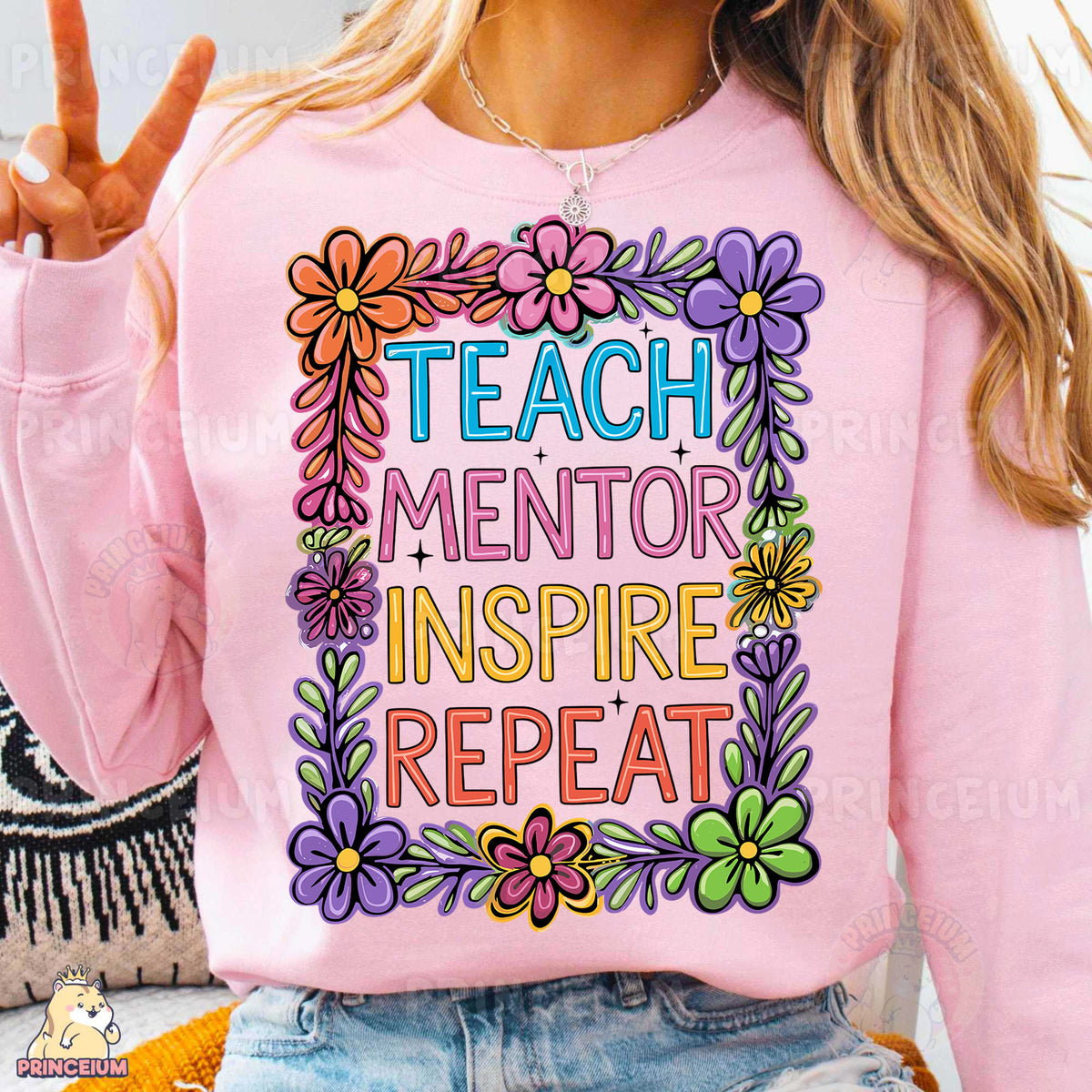 a woman wearing a pink sweatshirt that says teach mentor inspire repeat
