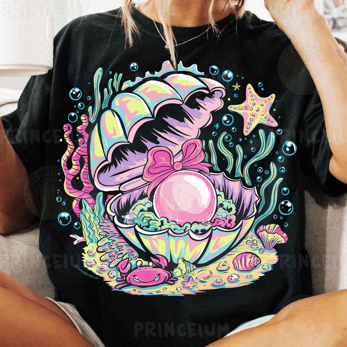 a woman sitting on a couch wearing a t - shirt with an image of a