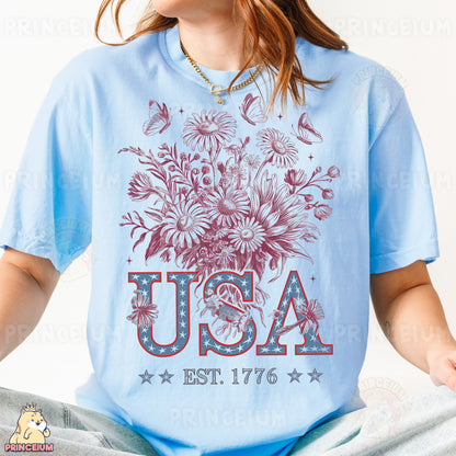 a woman in a blue usa t - shirt sitting on a bed
