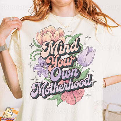 a woman wearing a t - shirt that says mind your own motherhood