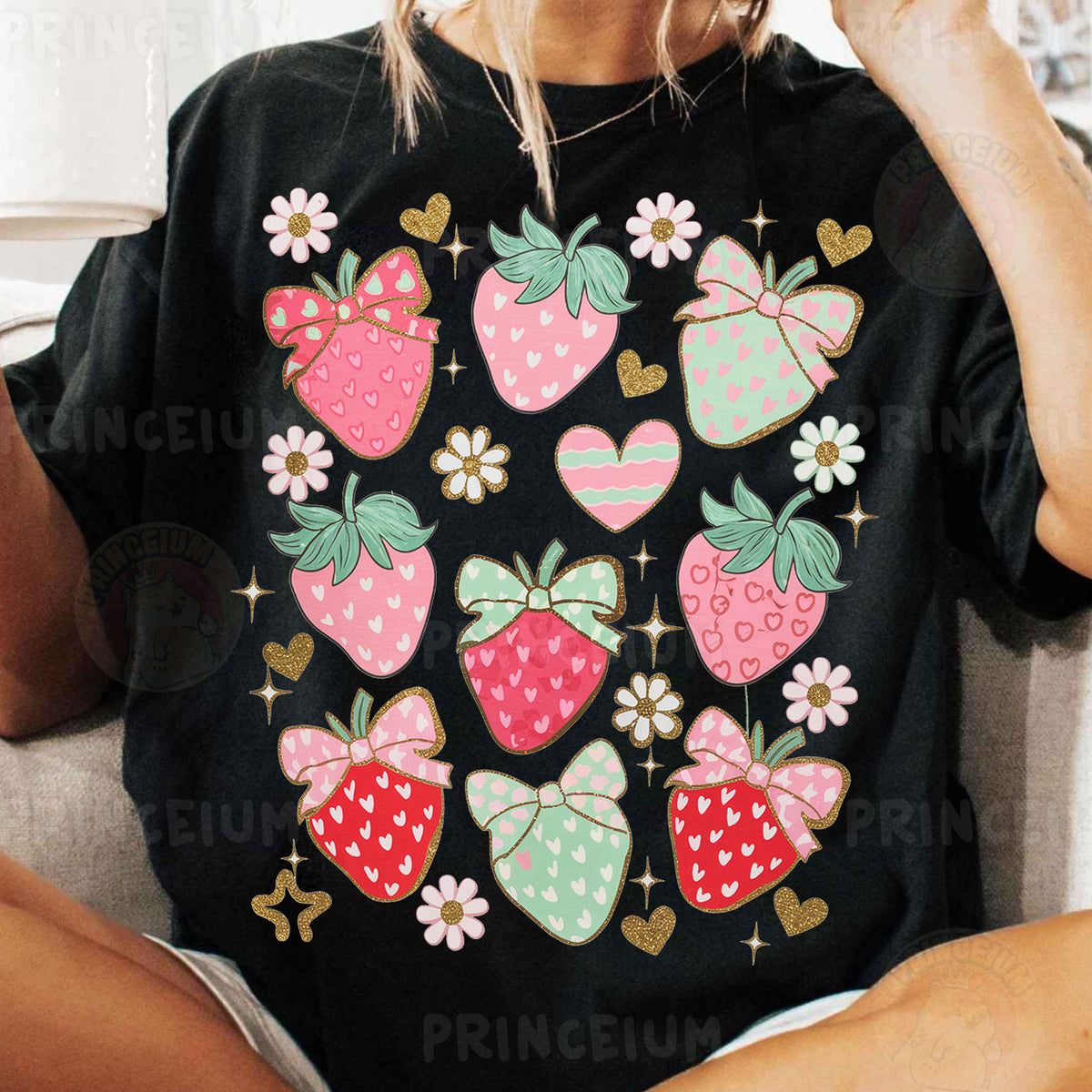 a woman sitting on a couch wearing a black shirt with strawberries on it