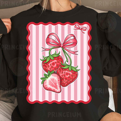 a woman wearing a black shirt with a pink bow and two strawberries on it