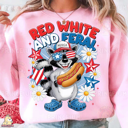 a woman wearing a pink sweatshirt with a raccoon eating a hot dog