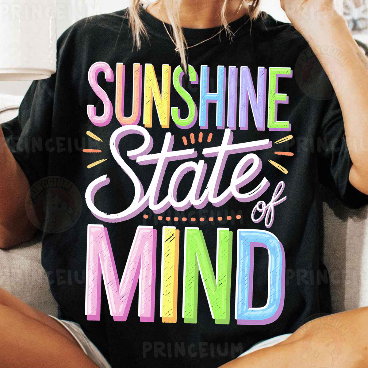 a woman sitting on a couch wearing a black shirt that says sunshine state of mind