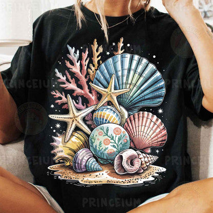 a woman sitting on a couch wearing a black shirt with seashells and star