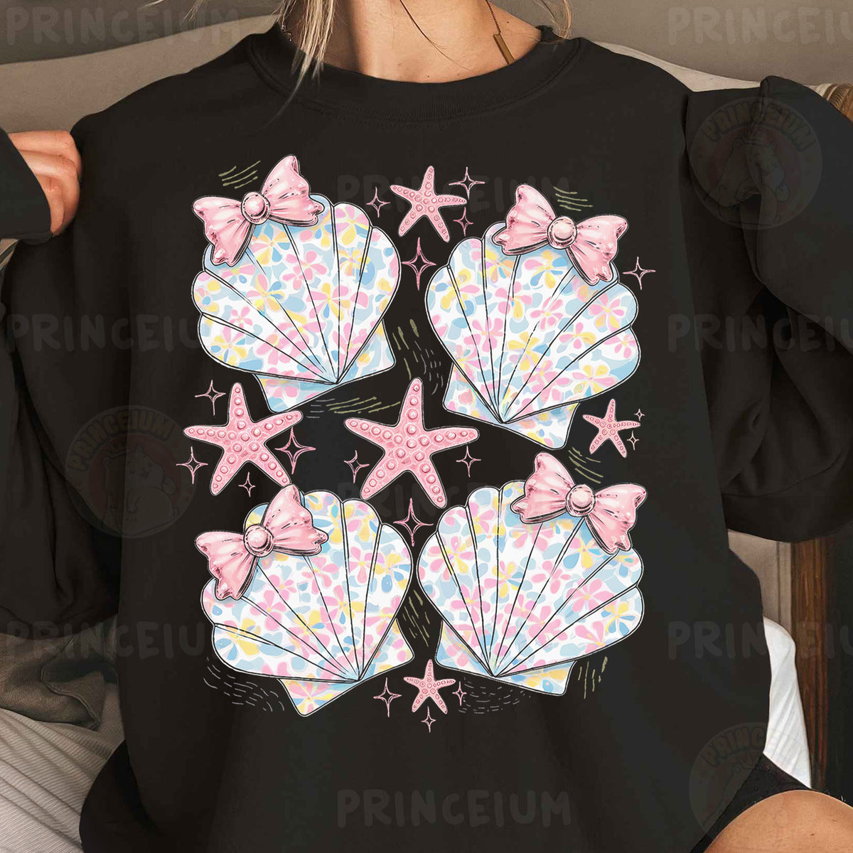 a woman wearing a black shirt with seashells and starfish on it
