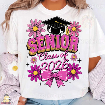 a woman wearing a white shirt with pink flowers and a graduation cap