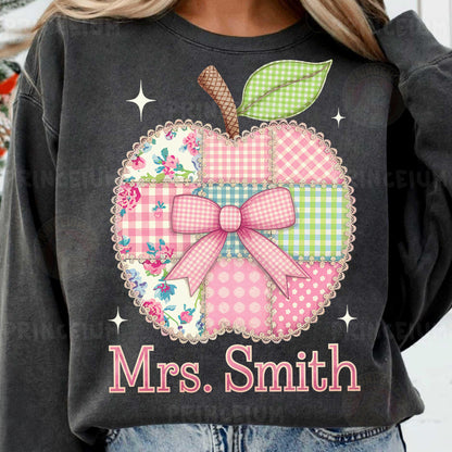 a woman wearing a black sweatshirt with a pink apple on it
