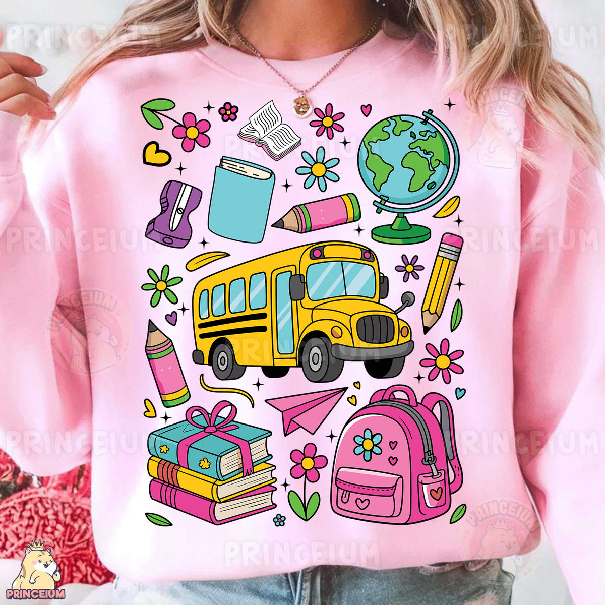 a woman wearing a pink sweatshirt with school supplies on it