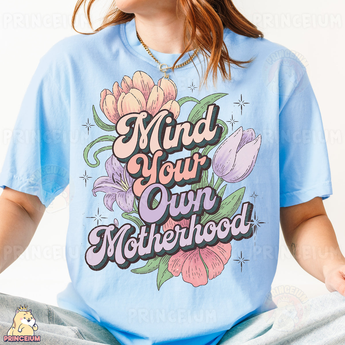 a woman wearing a blue t - shirt that says mind your own motherhood