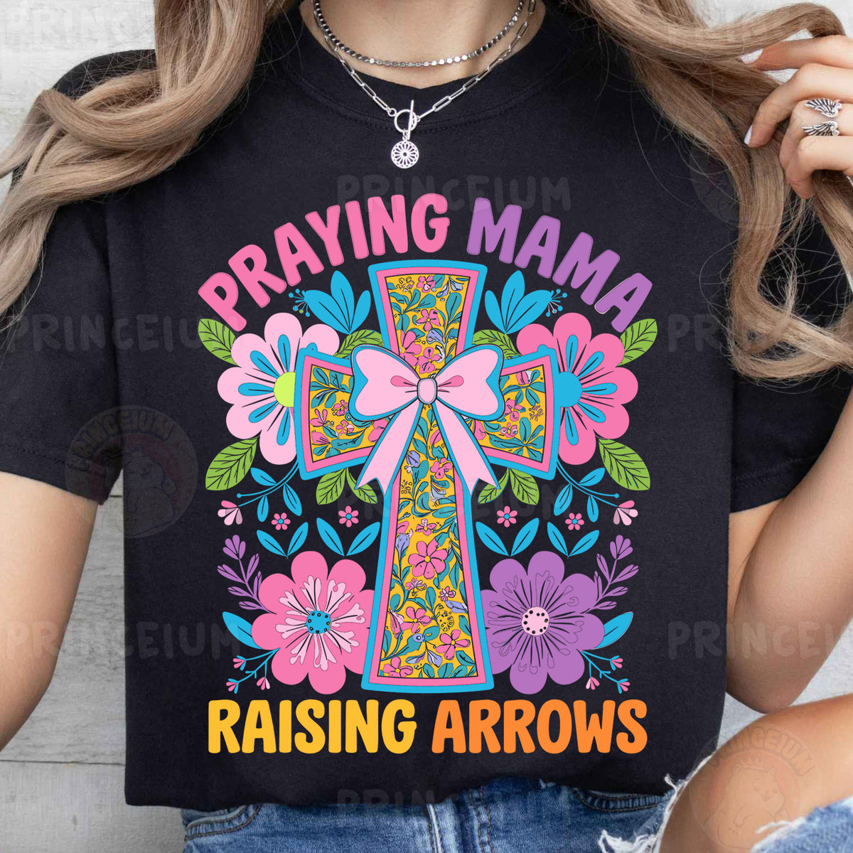 a woman wearing a t - shirt that says praying mama raising arrows