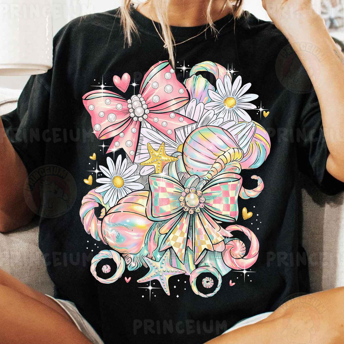 a woman sitting on a couch wearing a black shirt with pink bows on it