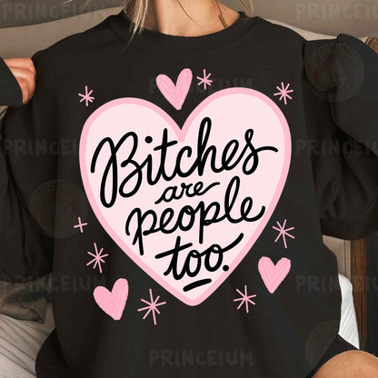 a woman wearing a black shirt with pink hearts and the words bitches are people