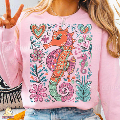 a woman wearing a pink sweater with a sea horse on it