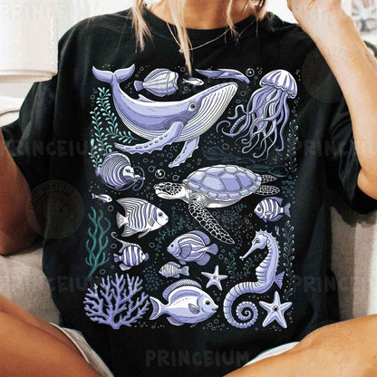 a woman sitting on a couch wearing a black shirt with sea animals on it
