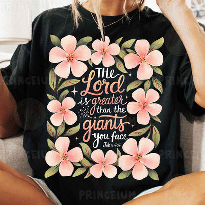 a woman sitting on a couch wearing a black shirt with pink flowers