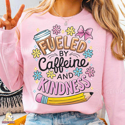 a woman wearing a pink sweatshirt that says fueled by caffeine and kind of