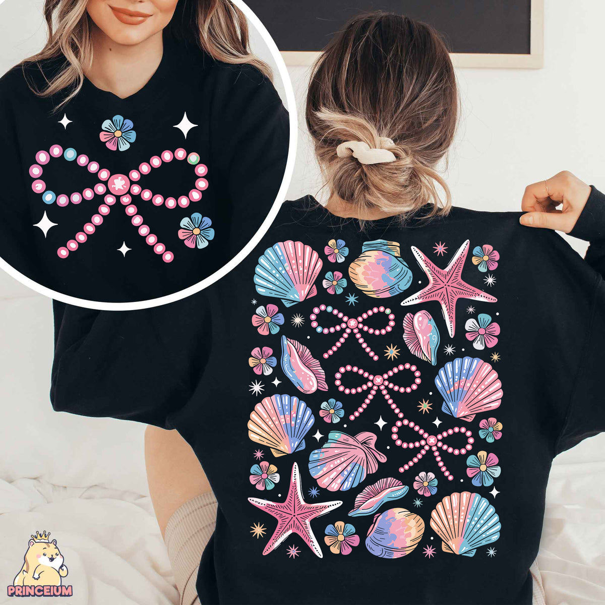 a woman wearing a black shirt with pink and blue seashells on it