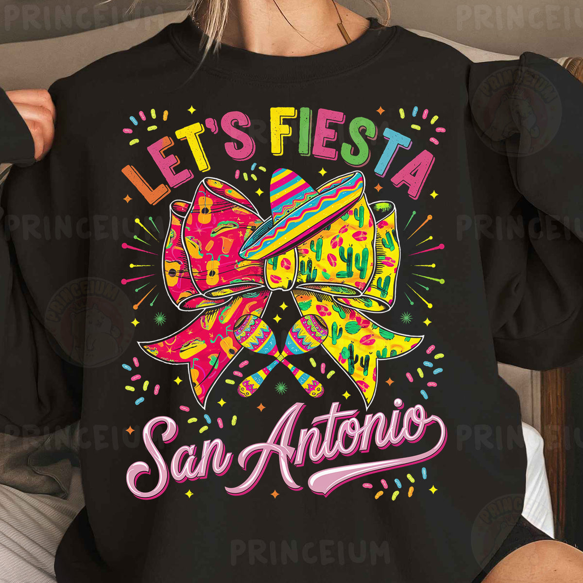 a woman wearing a black sweatshirt that says let's fiesta san antonio