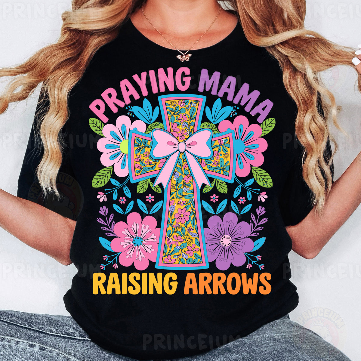a woman wearing a black t - shirt that says praying mama raising arrows