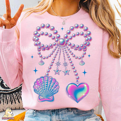 a woman wearing a pink shirt with pearls and hearts on it