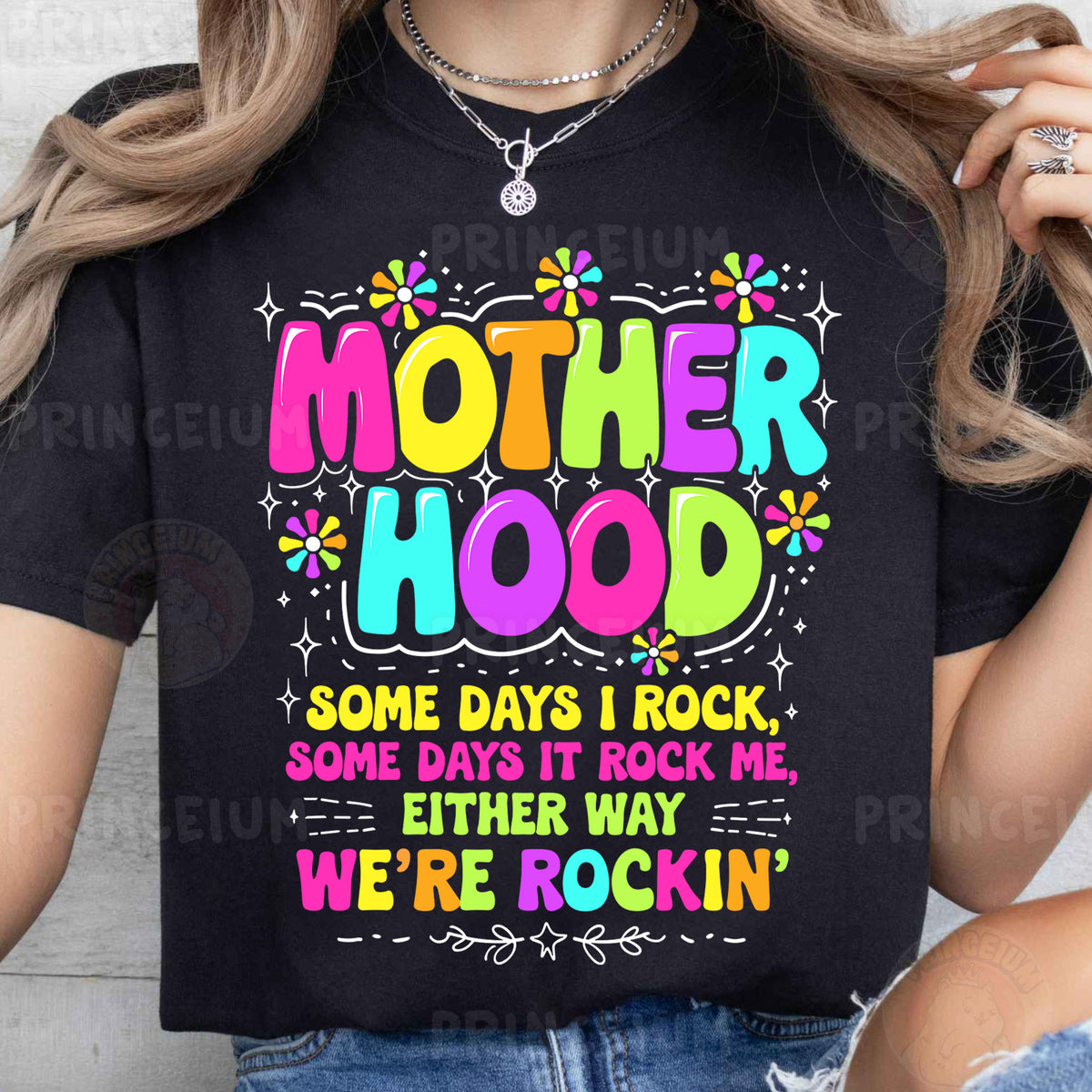 a woman wearing a black t - shirt that says motherhood some days i rock