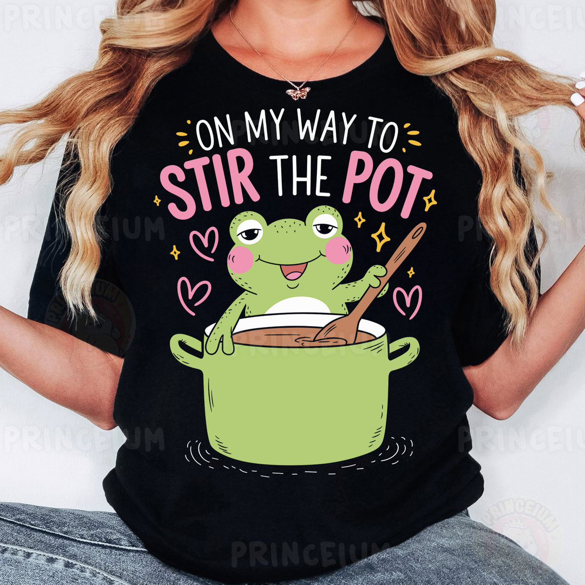 a woman wearing a black t - shirt with a frog in a pot on her
