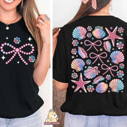 a woman wearing a black shirt with pink and blue seashells on it