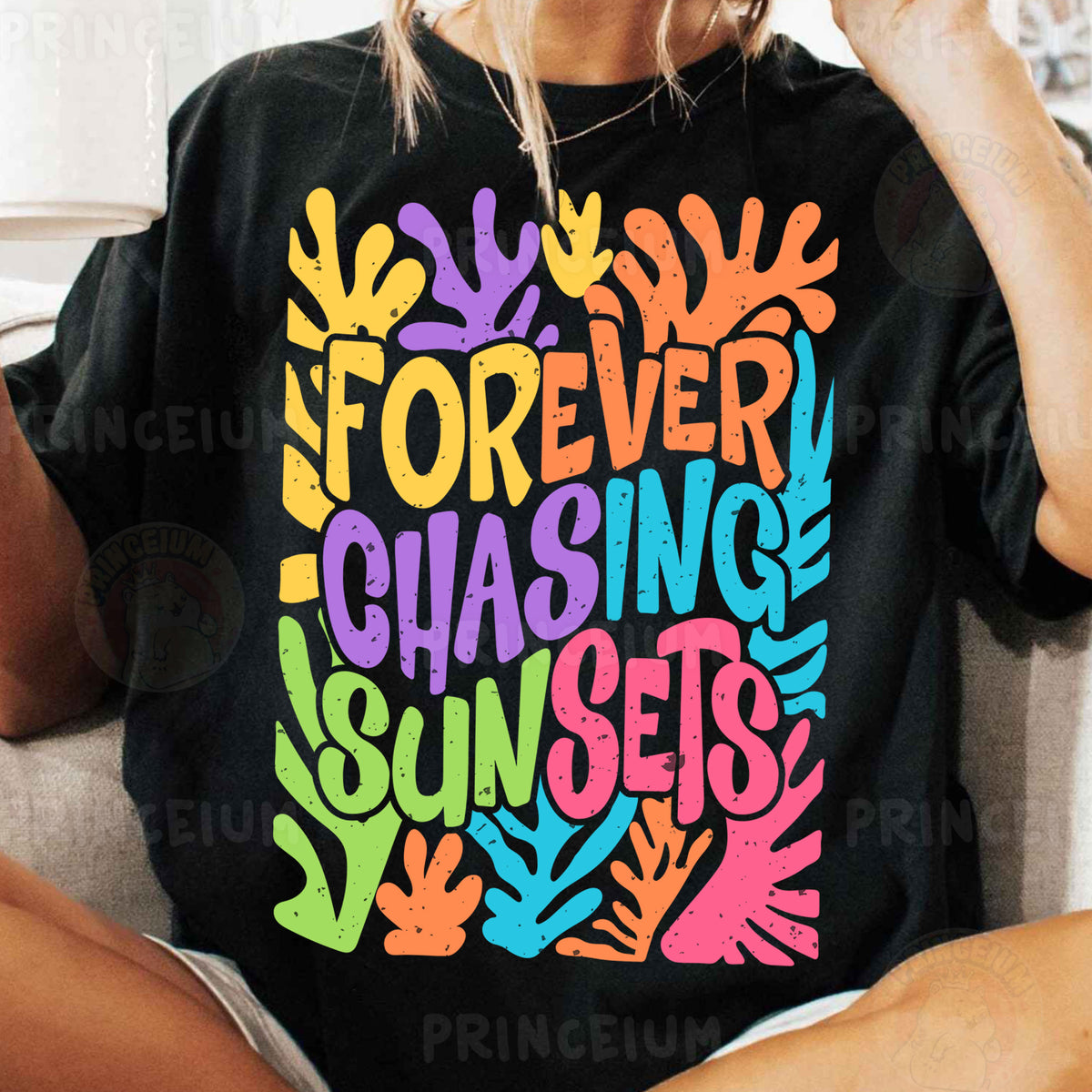 a woman sitting on a couch wearing a t - shirt that says forever chasing sunset
