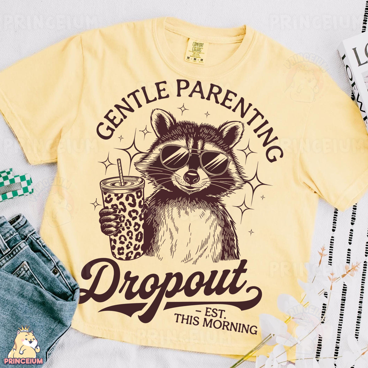 a yellow shirt with a raccoon holding a drink