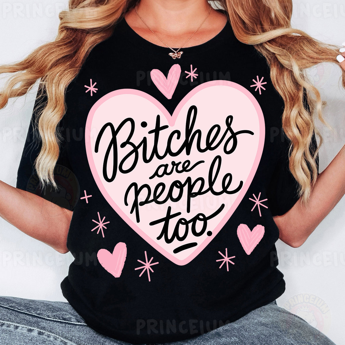 a woman wearing a black shirt with a pink heart and bitches are people too