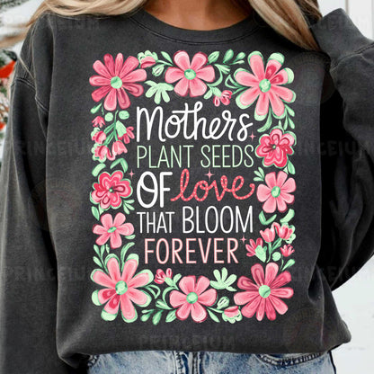 a woman wearing a sweatshirt that says mothers plant seeds of love that bloom forever