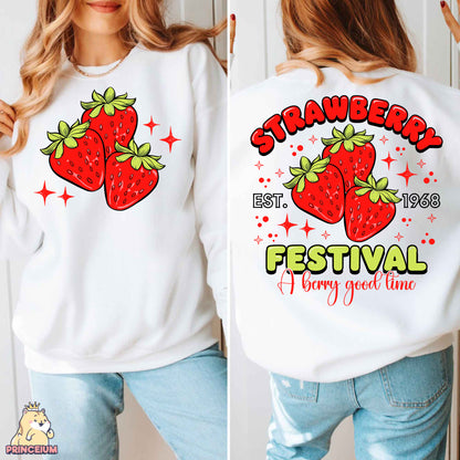 a woman wearing a white sweatshirt with strawberries festival on it