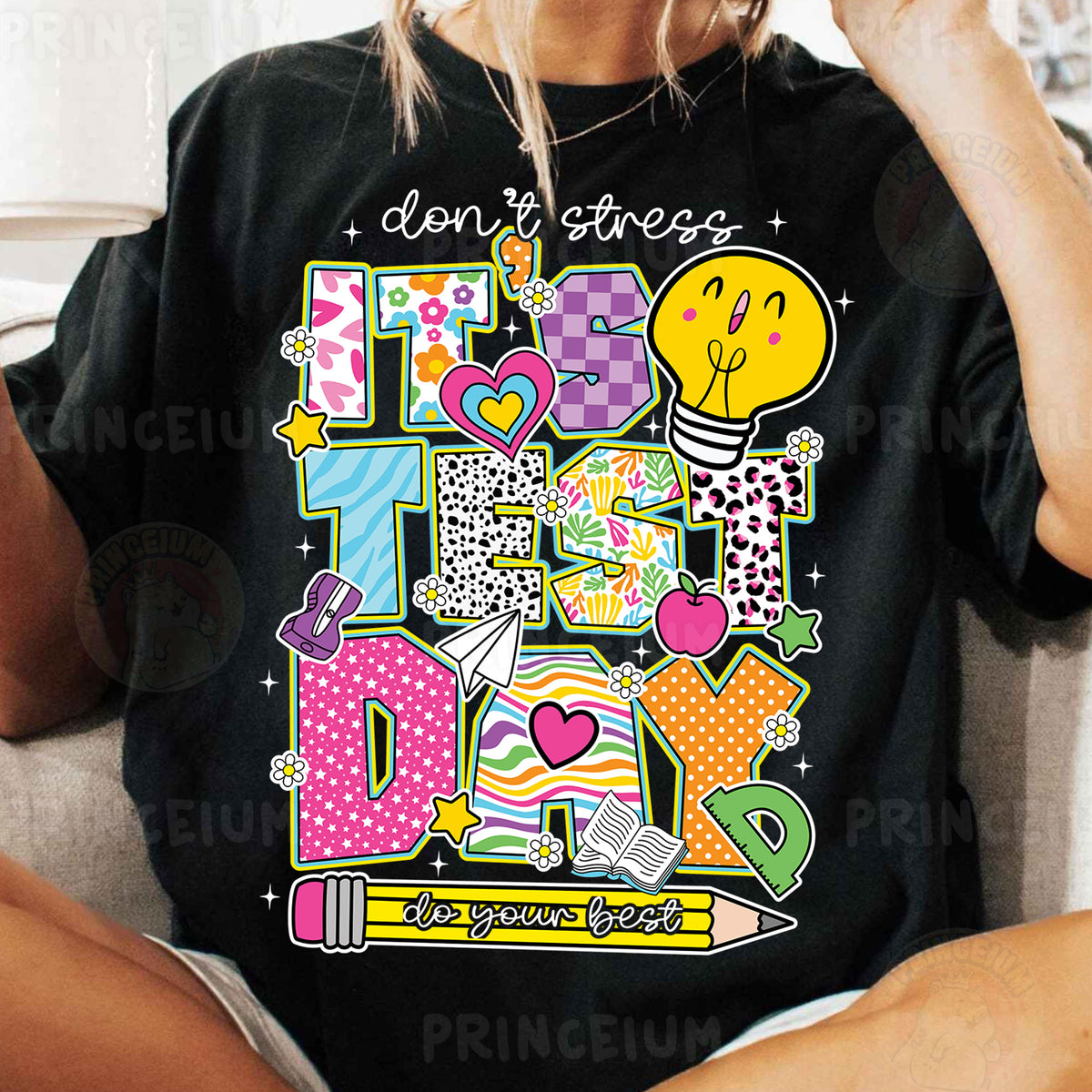 a woman sitting on a couch wearing a black t - shirt