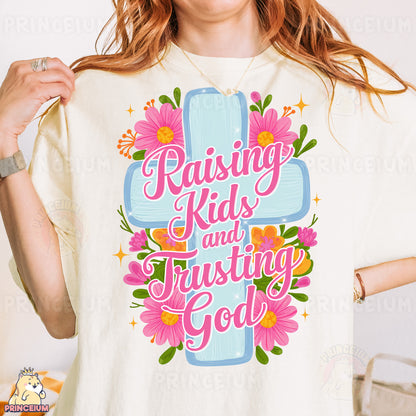 a woman wearing a t - shirt that says raising kids and trusting god