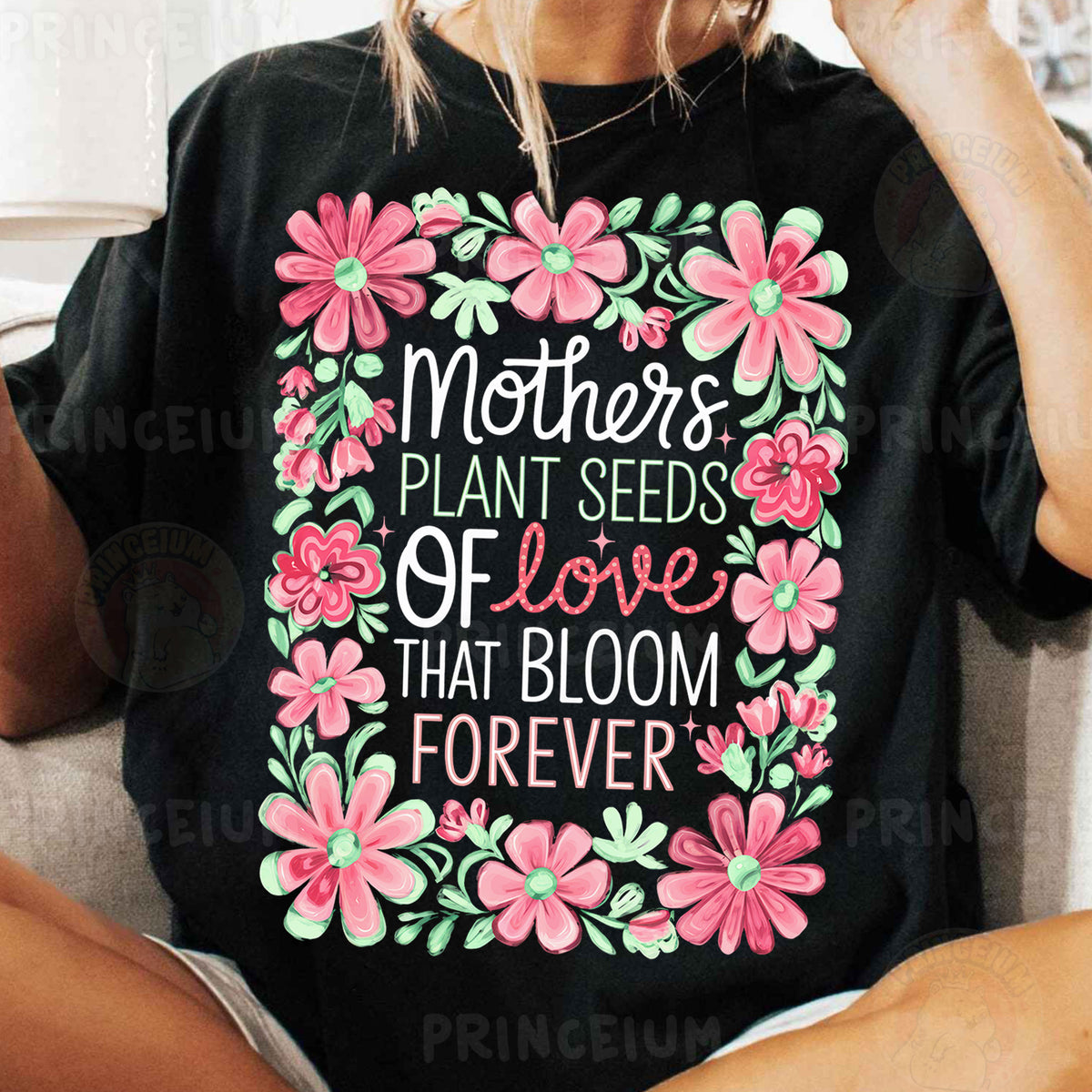 a woman sitting on a couch wearing a t - shirt that says mothers plant seeds
