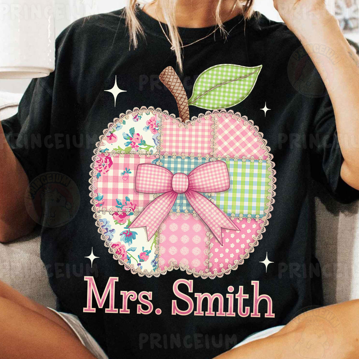 a woman wearing a black shirt with a pink apple on it