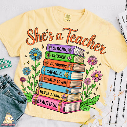 a t - shirt that says she's a teacher with a stack of books