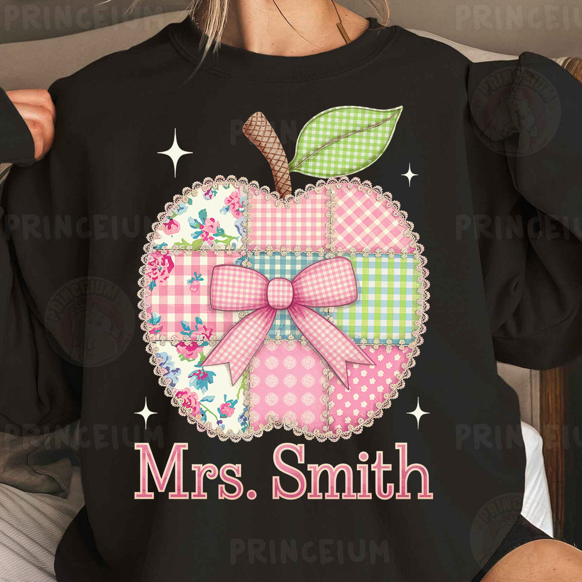 a woman wearing a black shirt with a pink apple on it