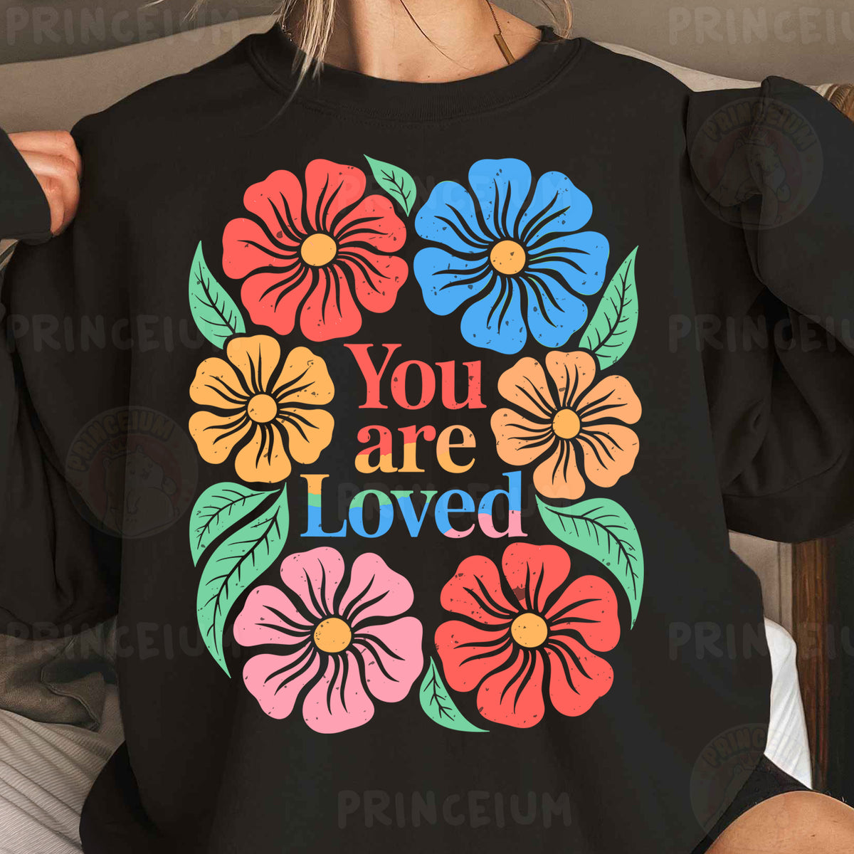 a woman wearing a black sweatshirt with colorful flowers on it