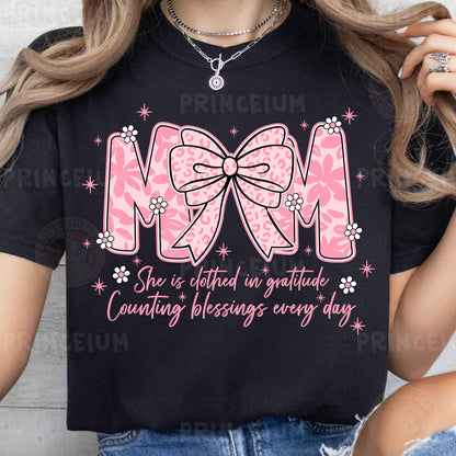 a woman wearing a mom shirt with a pink bow