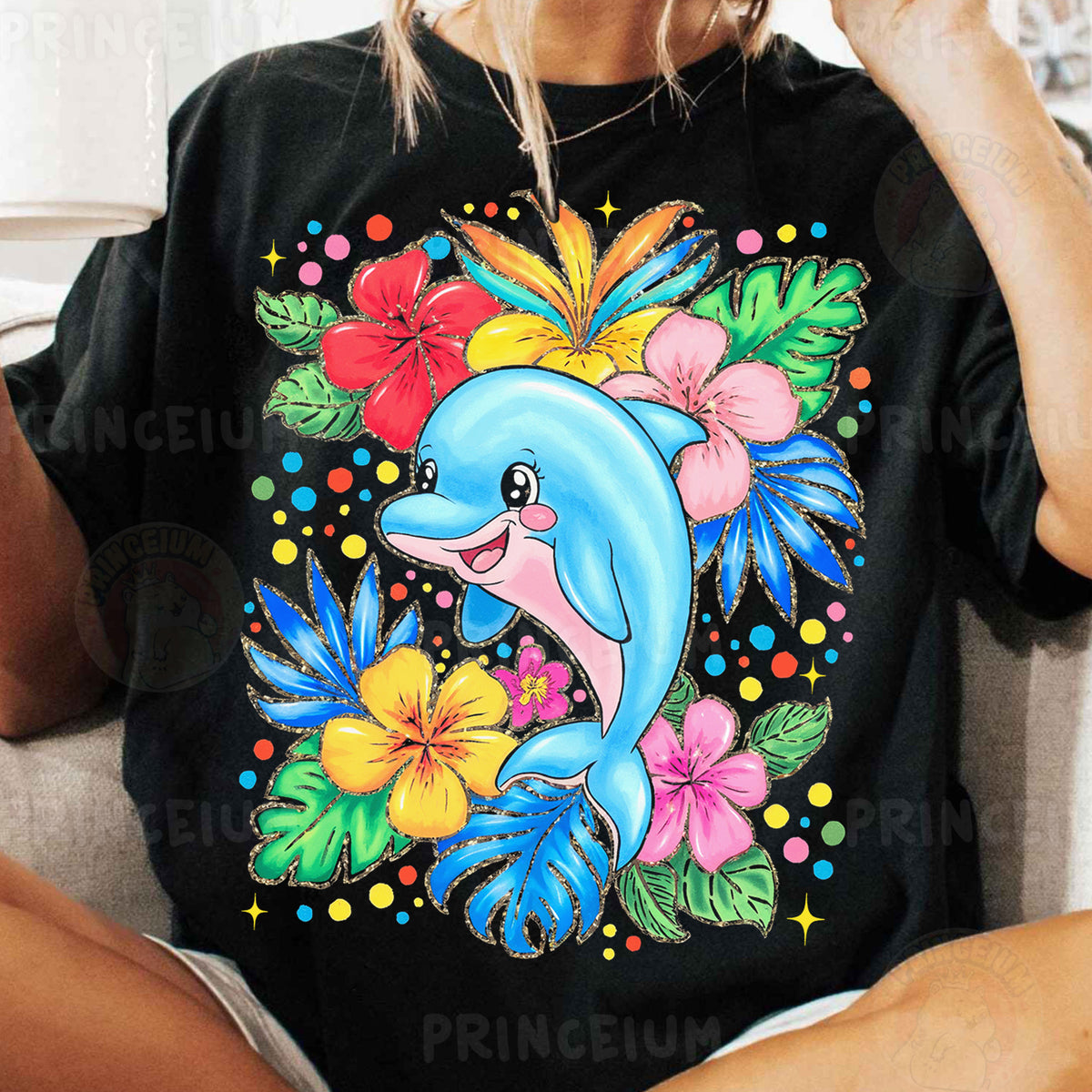 a woman sitting on a couch wearing a black shirt with a dolphin on it
