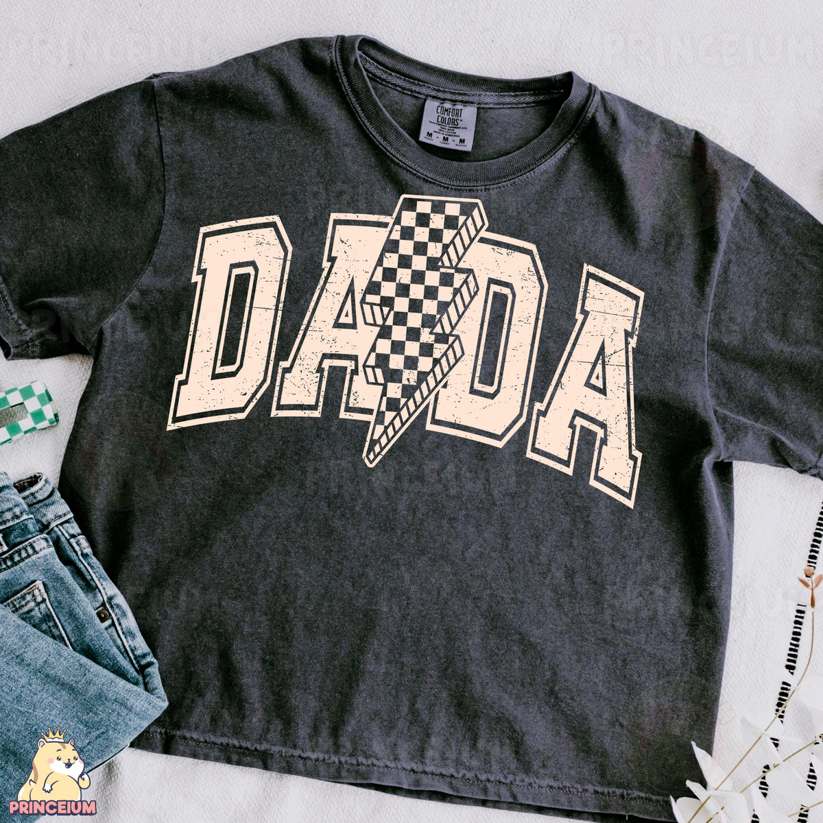 a t - shirt with the word dad on it next to a pair of jeans
