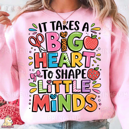 a woman wearing a pink sweatshirt that says it takes a big heart to shape little