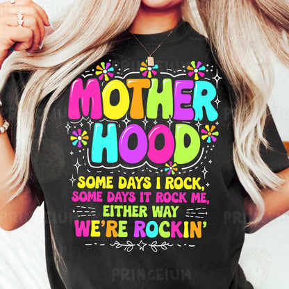 a woman wearing a black t - shirt that says motherhood some days i rock