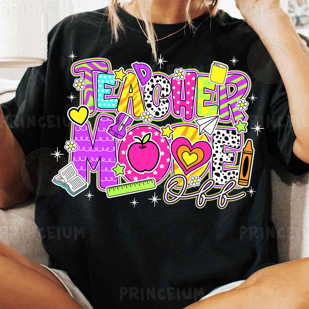 a woman sitting on a couch wearing a teacher mom shirt