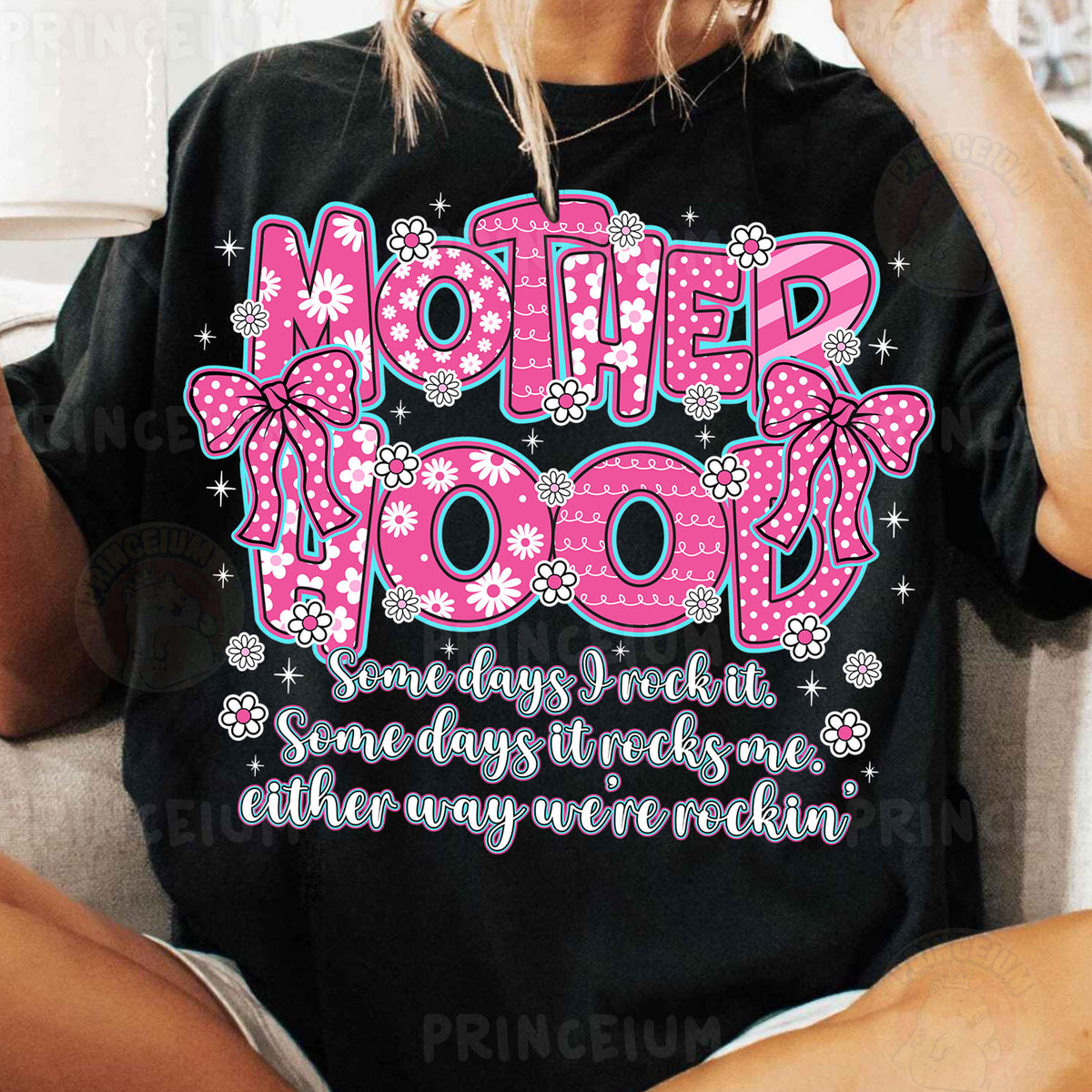 a woman sitting on a couch wearing a t - shirt that says motherhood